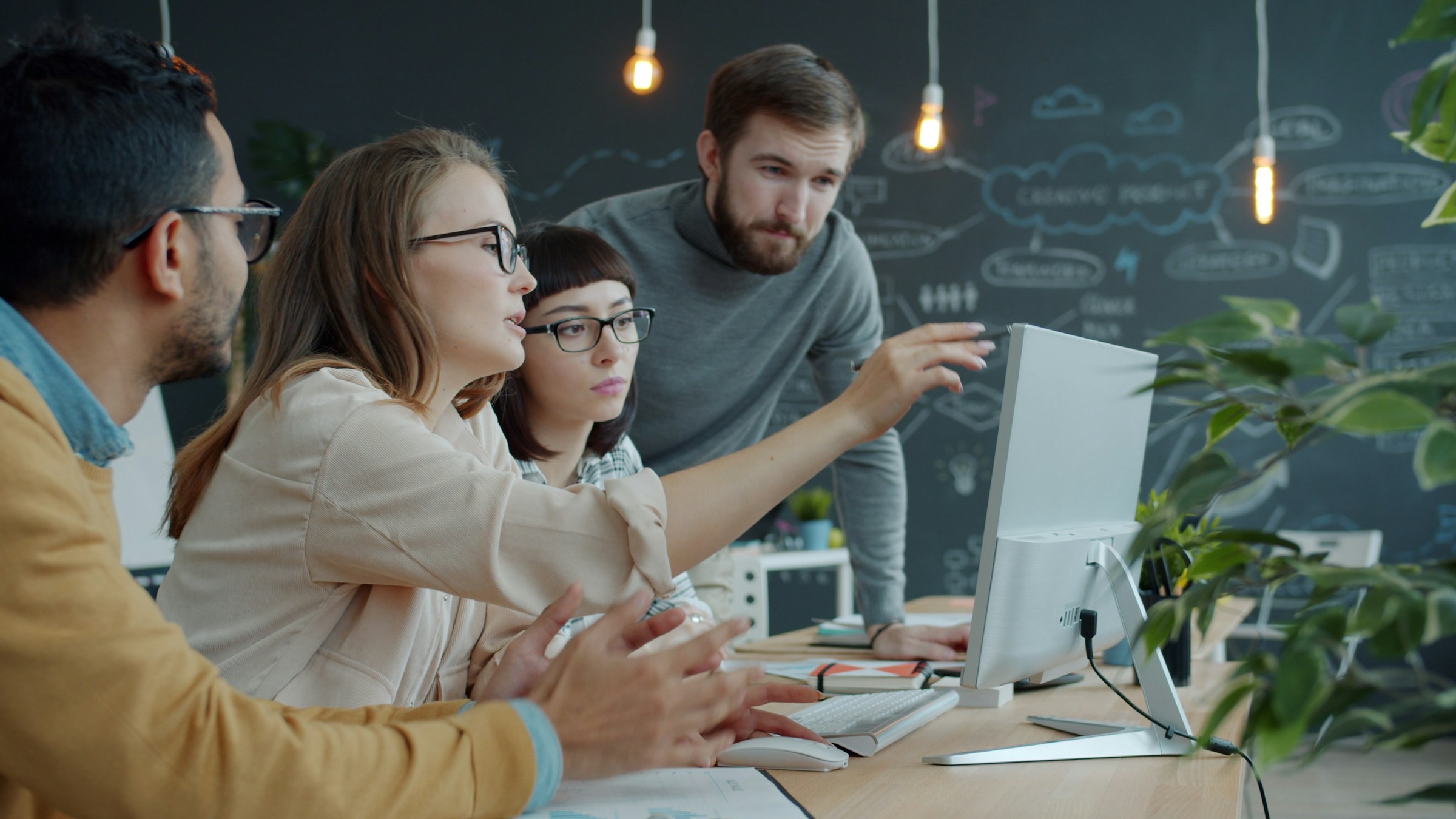 Illustrative stock photo of colleagues collaborating around a computer